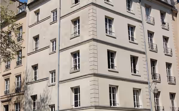 Immeuble parisien d'angle en pierre claire, façade sur rue
