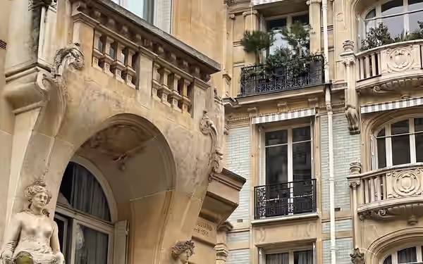 Détail de modénature sculptée : cariatides soutenant un balcon en pierre