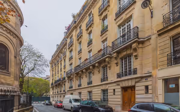 Perspective d'une rue parisienne bordée d'immeubles en pierre de taille